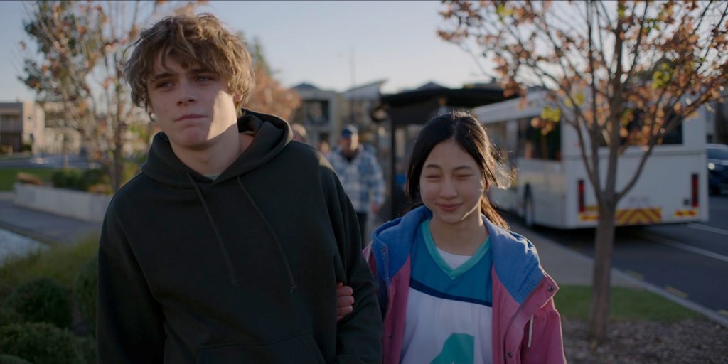 映画『ブリング・ハー・バック』の一場面/兄・アンディと妹・バイパーが一緒に歩いている